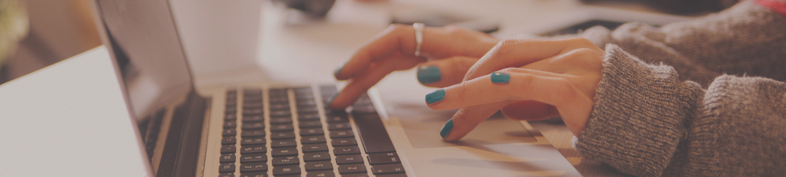 Hands typing on a laptop