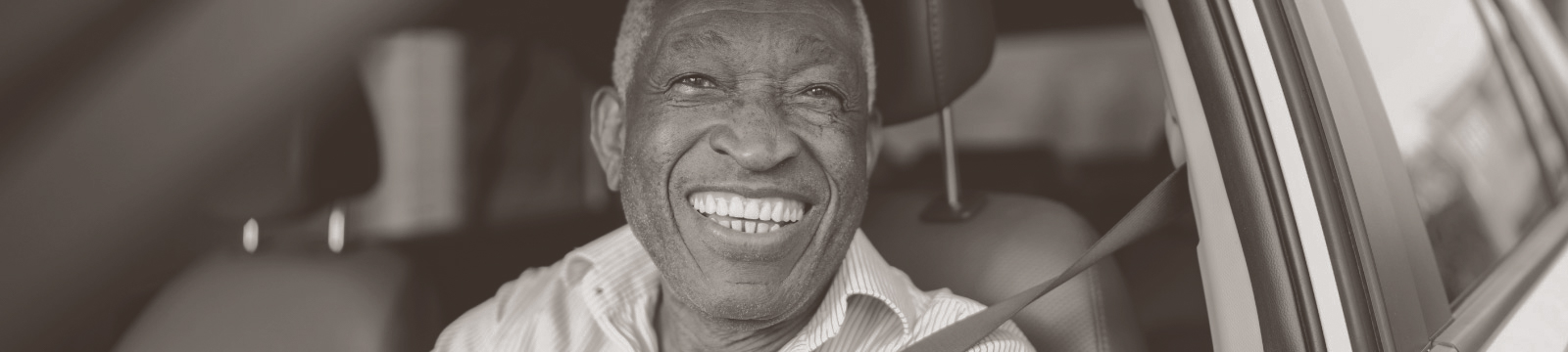 Mature happy man sits in his car.