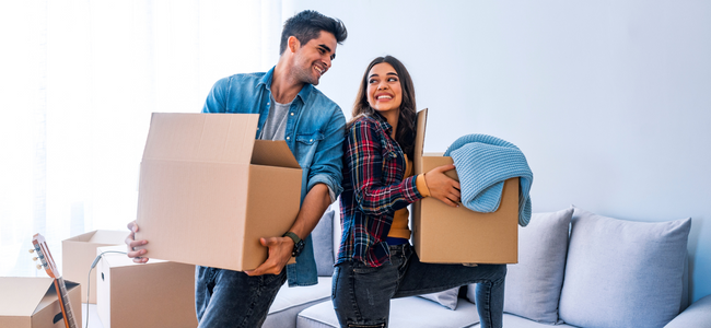 Man and Woman lifting boxes and smiling