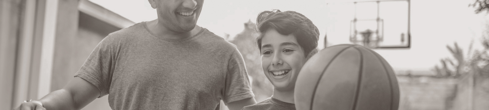 Father walks with son holding a basketball.