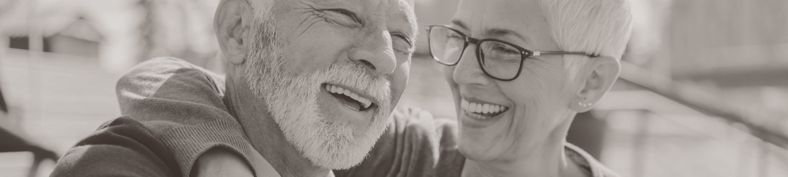 Mature couple laugh with one another.